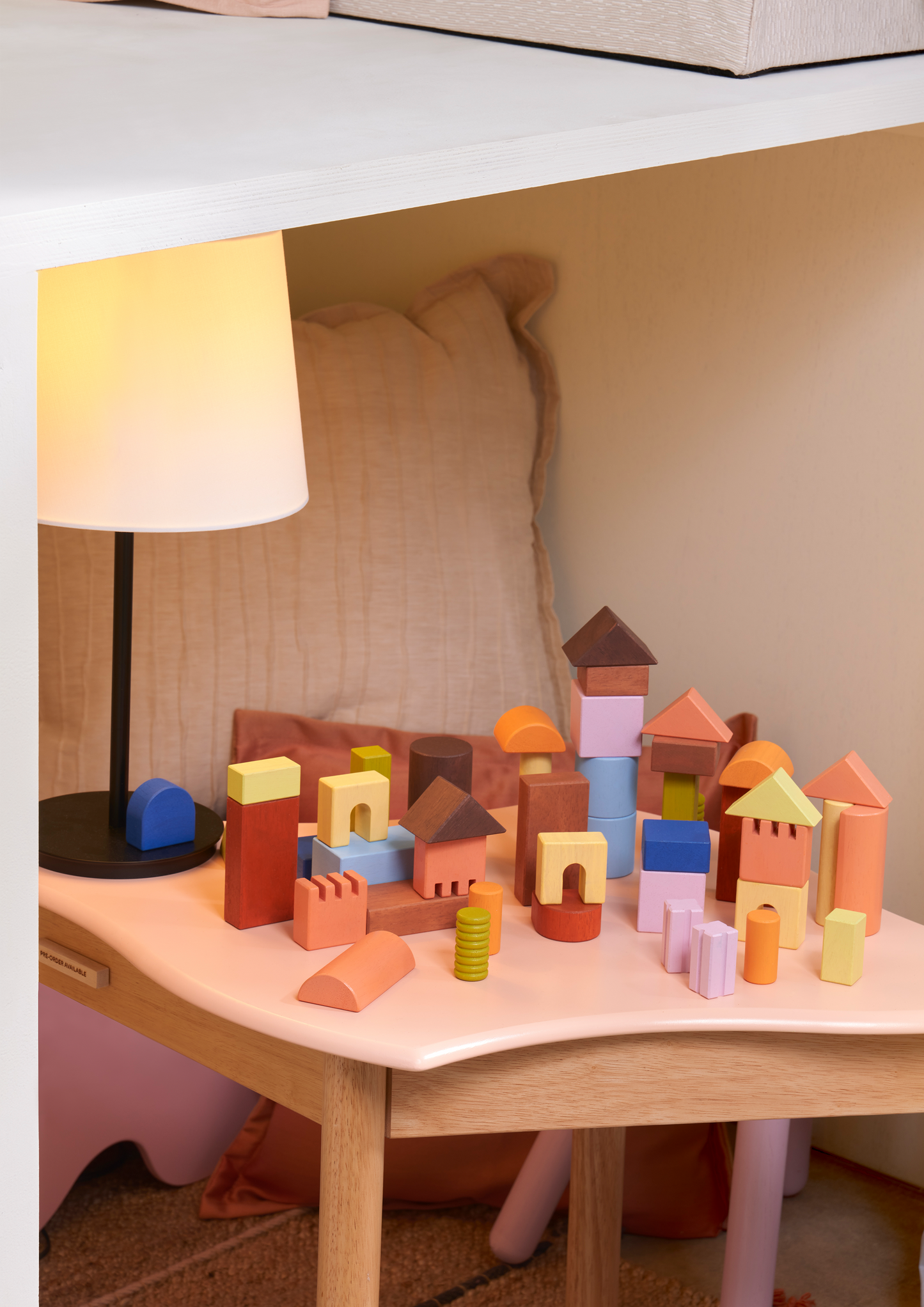 Natural wood unit blocks in cubes, triangles, half-cylinders, columns, and half-circles. Encourages spatial thinking, creativity, and open-ended play.