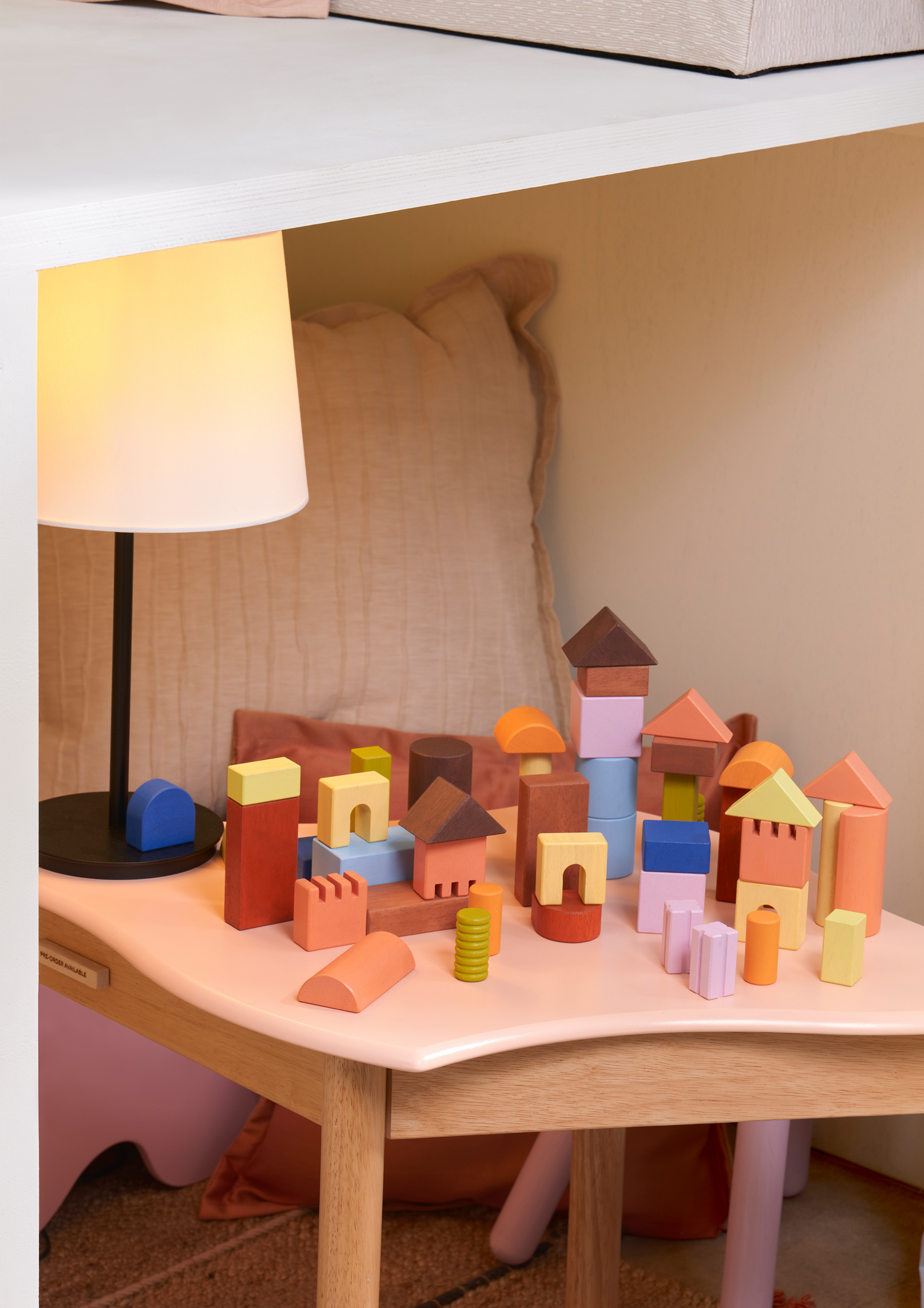 A variety of wooden blocks in different shapes including cubes and cylinders, arranged to form a larger cube-shaped structure.